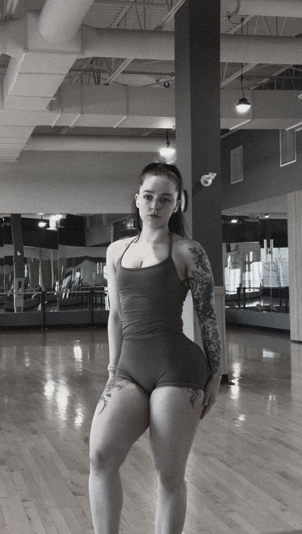 A woman is holding a surfboard on the beach